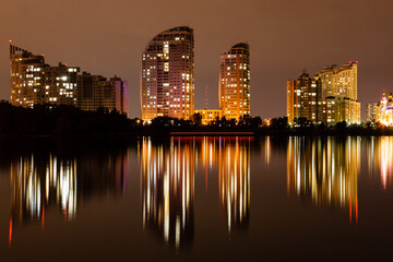 Fototapeta na wymiar night city with reflection of houses in the river
