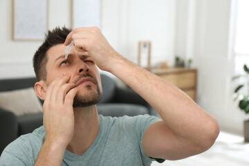 Man using drops for eyes at home