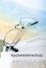Fototapeta na wymiar Hochwasserschutz - Symbolfoto mit Brille und Zeitung