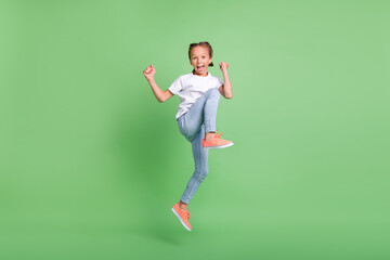 Fototapeta na wymiar Full length body size photo little girl jumping up gesturing like winner isolated pastel green color background
