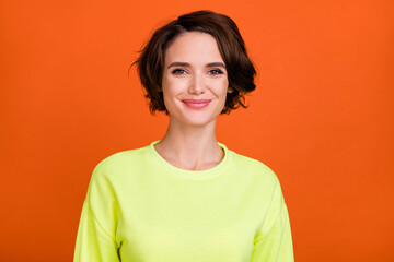 Fototapeta premium Photo of pretty young positive woman smile good mood wear yellow sweatshirt isolated on orange color background