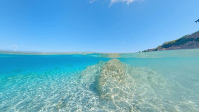 Split-shot, over-under shot. Stunning view of half underwater half sky with a beautiful and turquoise water. Liscia Ruja, Sardinia, Italy.