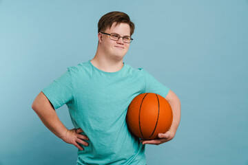 Young man with down syndrome smiling and holding basketball