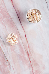 White bowl with popcorn on white and red marble.