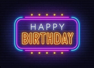 Happy birthday neon sign. Greeting card on brick wall background.