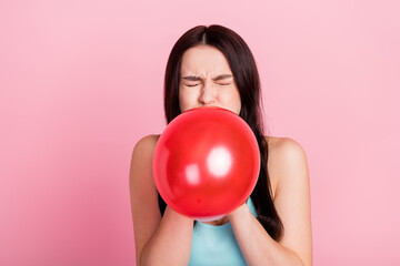 Photo of funny millennial birthday lady blow balloon close eyes wear blue top isolated on pink...