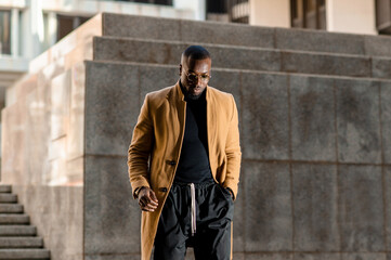 Fototapeta premium African man in elegant stylish suit walking in a metropolitan city.