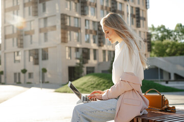 Young successful businesswoman using laptop for work outdoors