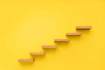 Wooden staircase on yellow background. Growth, increasing business, success process concept. Copy...