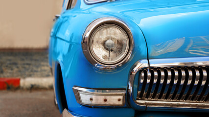 Blue retro car. Old vintage car. Headlight close up.