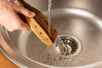 Washing a spatula under the water