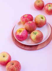 Ripe apples are lying on a pink background in a dessert pink plate