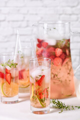 Fototapeta na wymiar Strawberry summer cocktail or lemonade with thyme and lemon. Cold refreshing organic soft drink with ripe berries in a glass