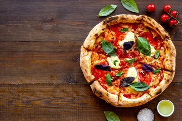 Pizza margarita with tomatoes and basil on the table
