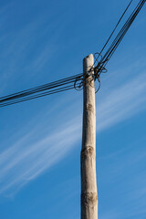 Looking up at telegraph pole with many wires