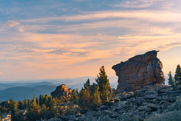 Panorama of a rocky valley in sunlight at the top of a mountain. Mountain range against the blue sky at sunset.