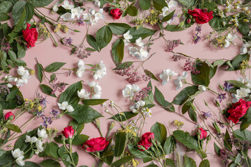 Floral flat lay background with fresh flowers and leaves.