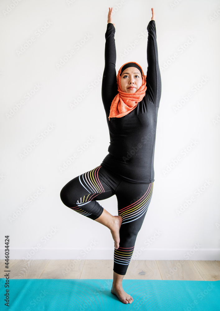 Wall mural muslim woman doing yoga in the room