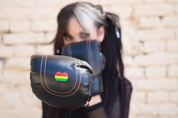 young and beautiful girl with a punky tendency. She wears boxing gloves and a heart in rainbow...