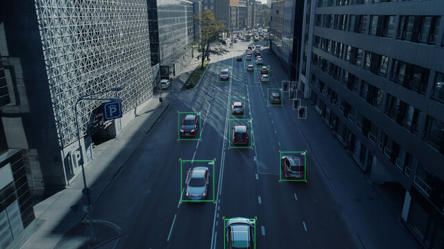 Aerial Drone Shot: Autonomous Self Driving Cars Moving Through City. Concept: Artificial Intelligence Scans Cars And Pedestrians, Following Movement And Showing Data.