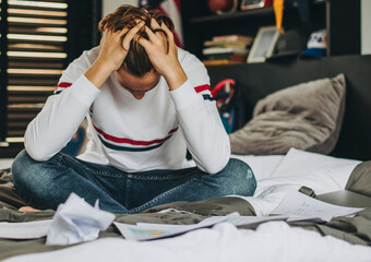 Stressed teen sitting in his bedroom