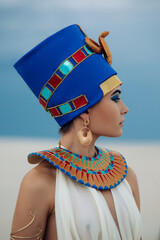 Portrait of woman in image of egyptian queen Nefertiti in desert.
