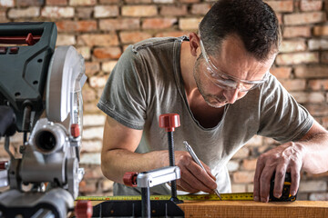 Professional carpenter working with a miter saw.