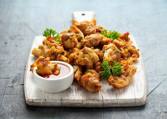 Chicken Pakora dish with sweet chilli sauce on white wooden board