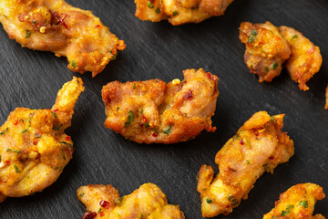 Chicken Pakora dish with sweet chilli sauce on rustic stone board