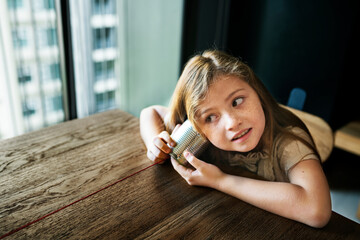 Little girl playing with a can phone