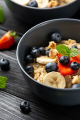 Healthy Oatmeal porridge breakfast with strawberry, blueberry, banana and honey