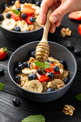 Healthy Oatmeal porridge breakfast with strawberry, blueberry, banana and honey