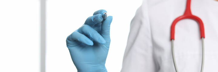 Doctor in protective gloves holding ballpoint pen closeup