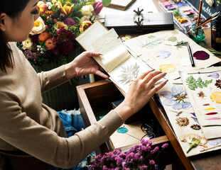 Woman looking a dried flower book