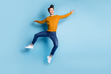 Full body photo of crazy brunet millennial guy dance wear sweater jeans isolated on blue color background