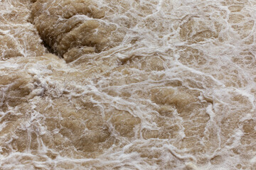 Water foam texture, rough water on the river, natural background, flood, power in nature concept. Rough water, furious current on the river.