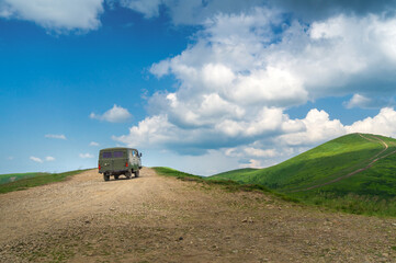 Fototapeta premium Travel to the top of the mountain on an old bus. Summer tourism and trekking to the mountains