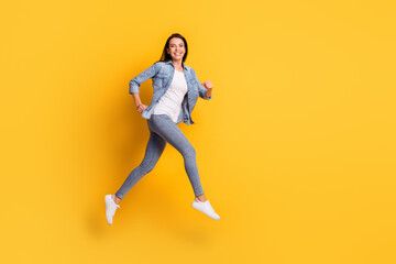 Fototapeta na wymiar Full size profile portrait of pretty carefree girl running look camera beaming smile isolated on yellow color background