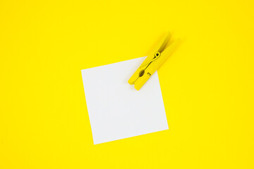 Blank white To Do List Sticker with yellow wooden clothespin. Close up of reminder note paper on...