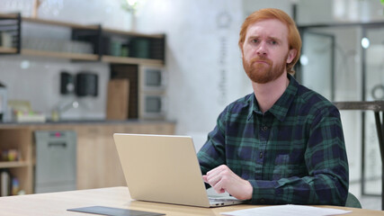 Redhead Man with Laptop showing No Gesture, Disapprove 