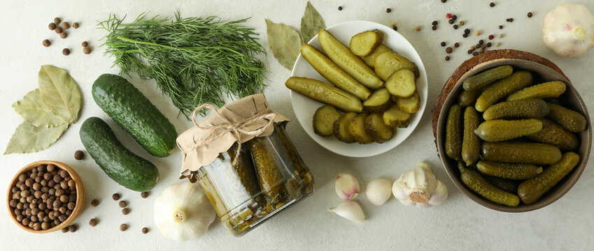 Fresh pickles and ingredients on white textured table