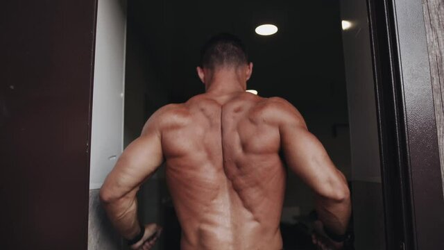 The bodybuilder shows the result of his training and demonstrates a pose for the broadest muscles of the back