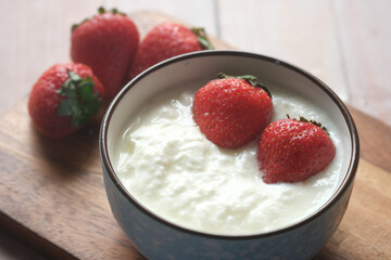 fresh strawberry and yogurt in a bowl on table 