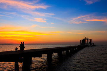 Silhouetted of a novice monk on the bridge in dusk