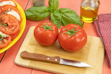 deux tomates crues et branches de basilic frais sur une table