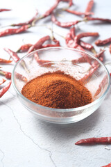 Chili powder and dried peppers on table background.