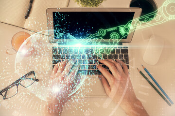 Multi exposure of man's hands typing over computer keyboard and data theme hologram drawing. Top view. Technology concept.