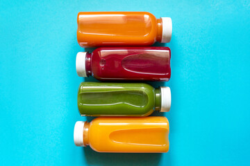 Fresh juices of fruits and vegetables in bottles on a blue background. The concept of a healthy diet or detox.