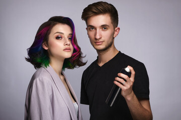 Hairdresser and beautiful woman with a perfectly multi-colored hair and classic make-up. Beauty face.