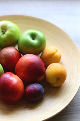 Wooden bowl with various colorful fruit. Selective focus.